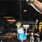 Barman pouring a cocktail into a glass at night club